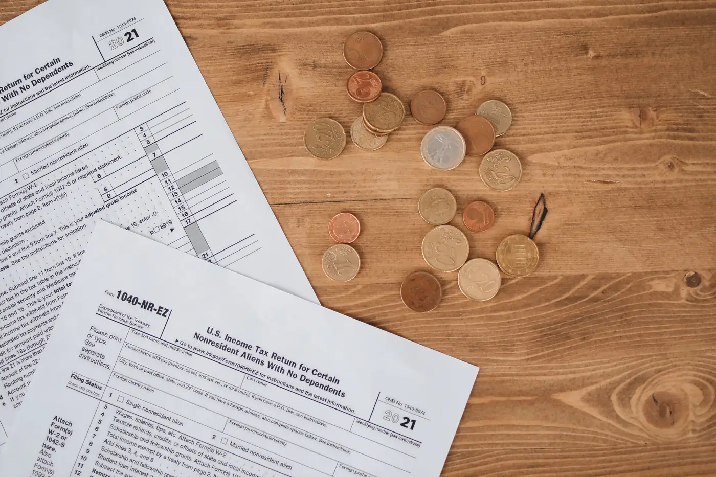Belastingformulieren en munten op een houten ondergrond