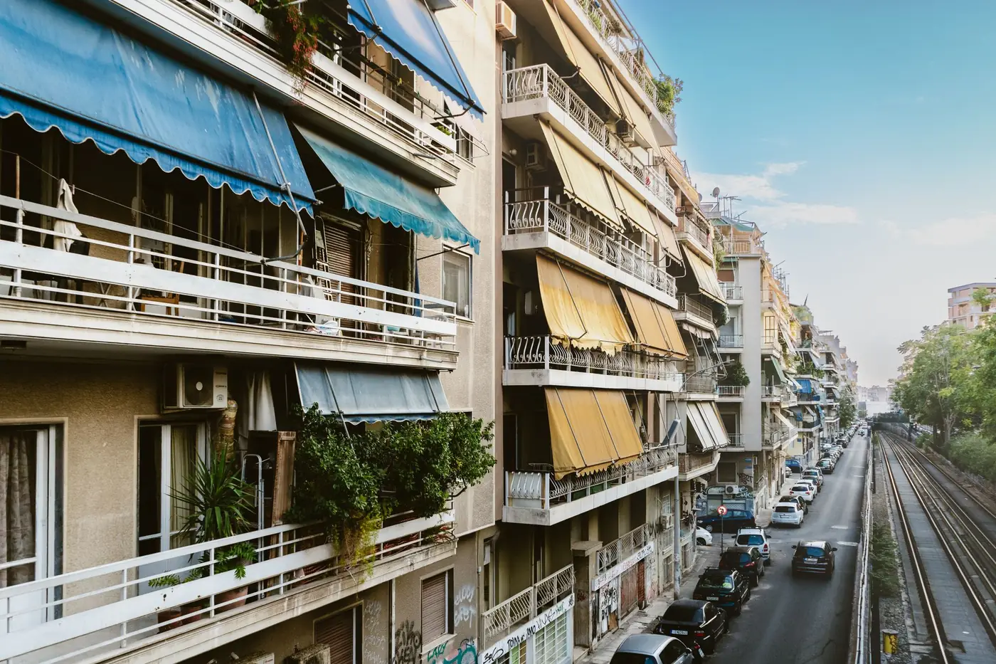 Woonstraat met appartementengebouwen en spoorlijn in Athene
