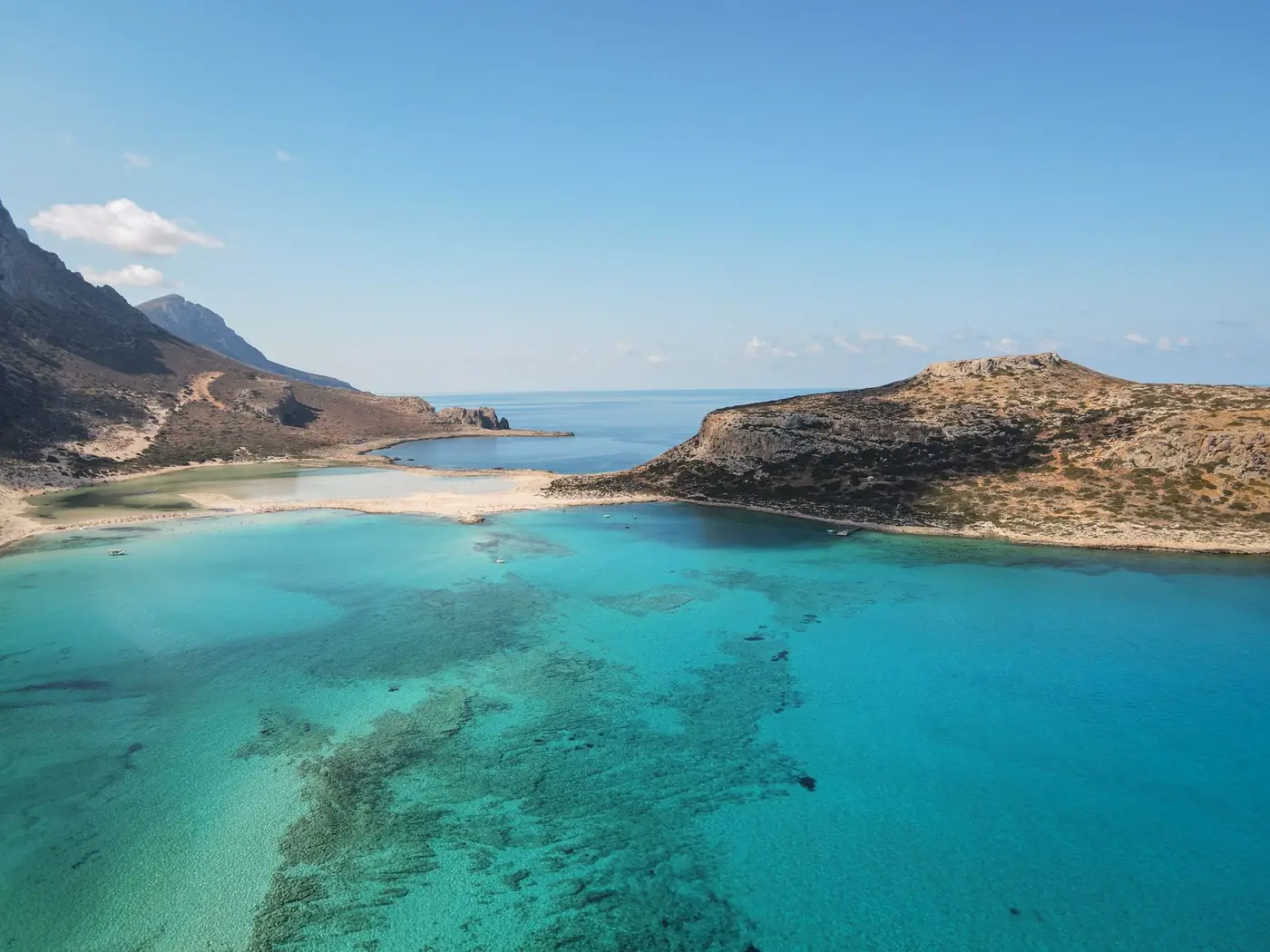 Luchtfoto van een turquoise lagune en rotsachtige kustlijn van een Grieks eiland
