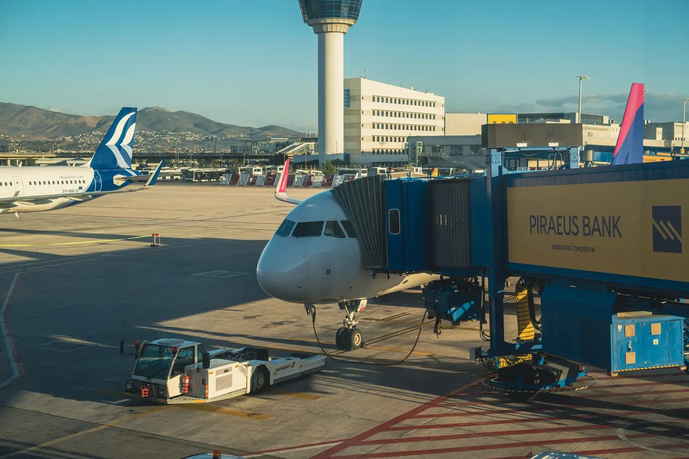 Vliegtuig aan de gate van een terminal op de luchthaven van Athene bij zonnig weer