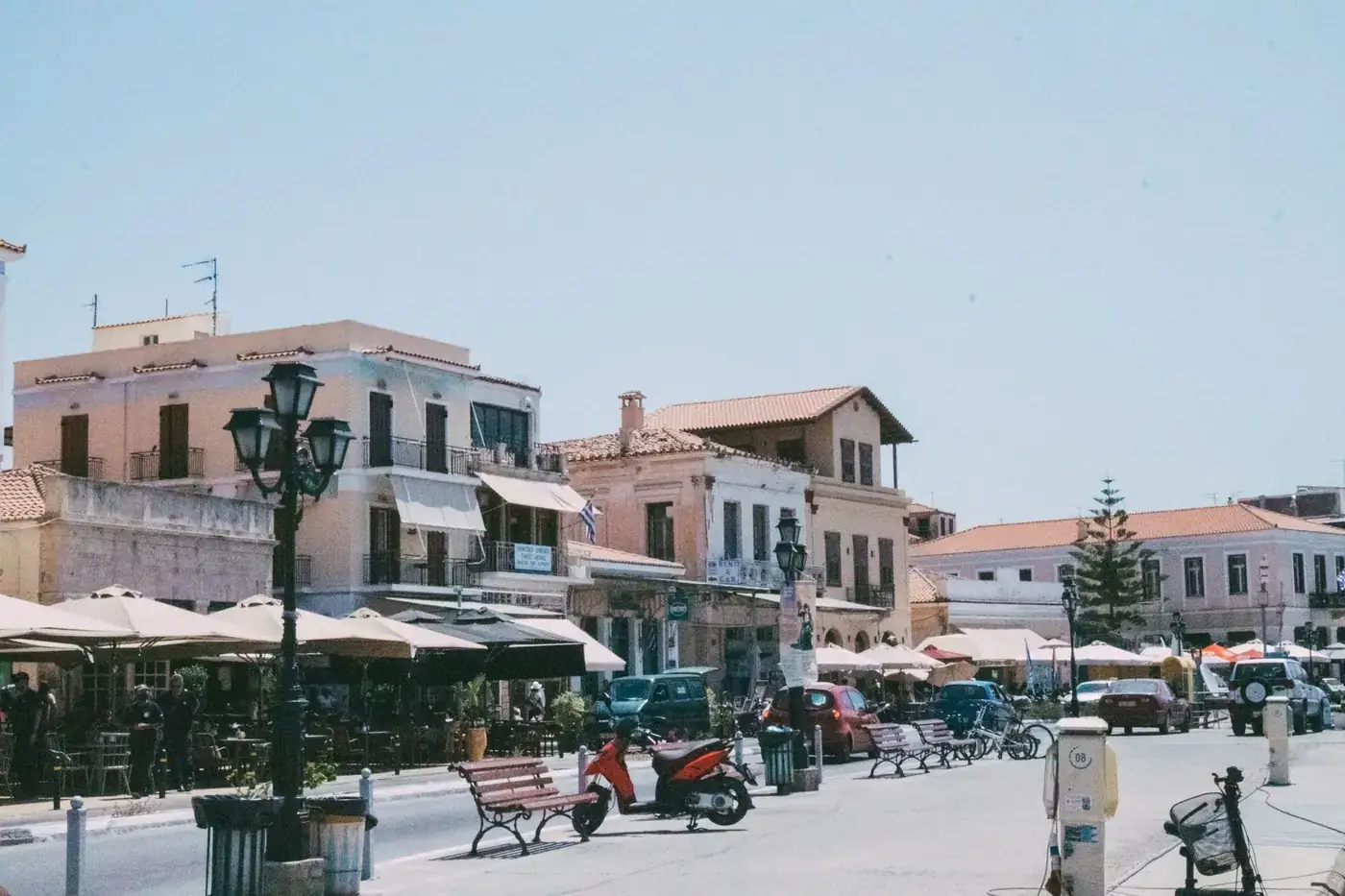 Vibrant street scene in a Mediterranean town with outdoor cafes and historic buildings.