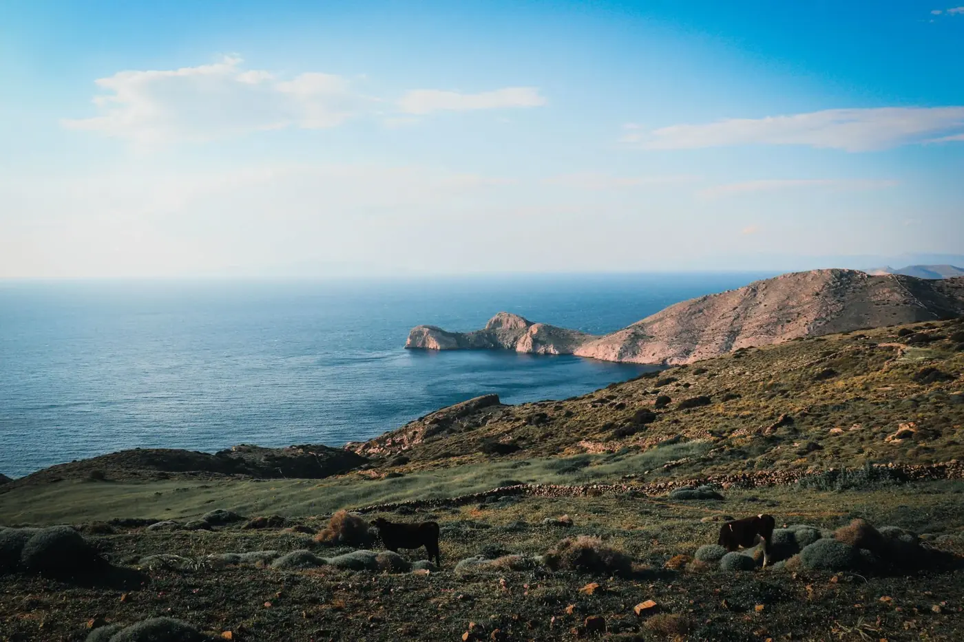 Breathtaking coastal landscape of Agios Stefanos, Greece featuring rocky hills and a tranquil sea.