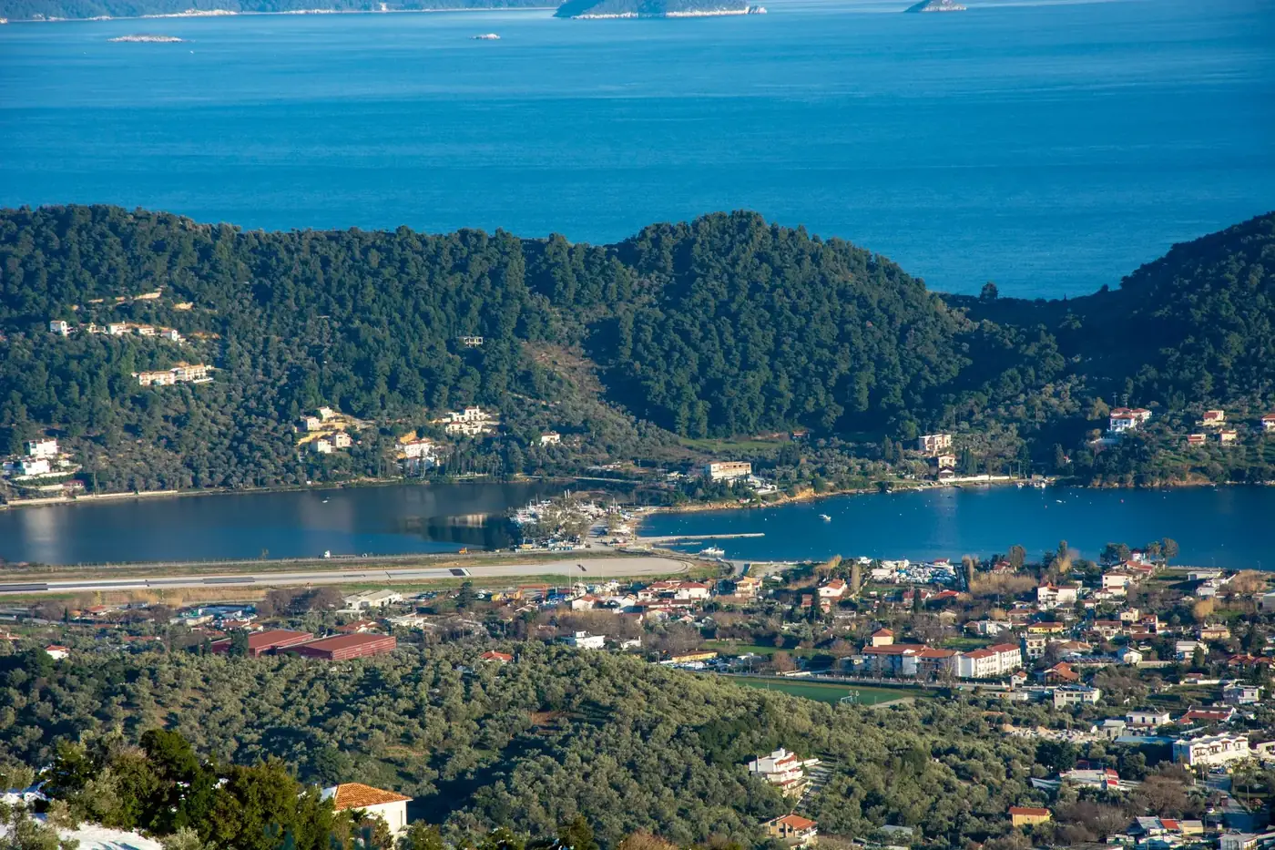 A breathtaking aerial view of Skiathos Island, showcasing its lush forests and tranquil coastline.