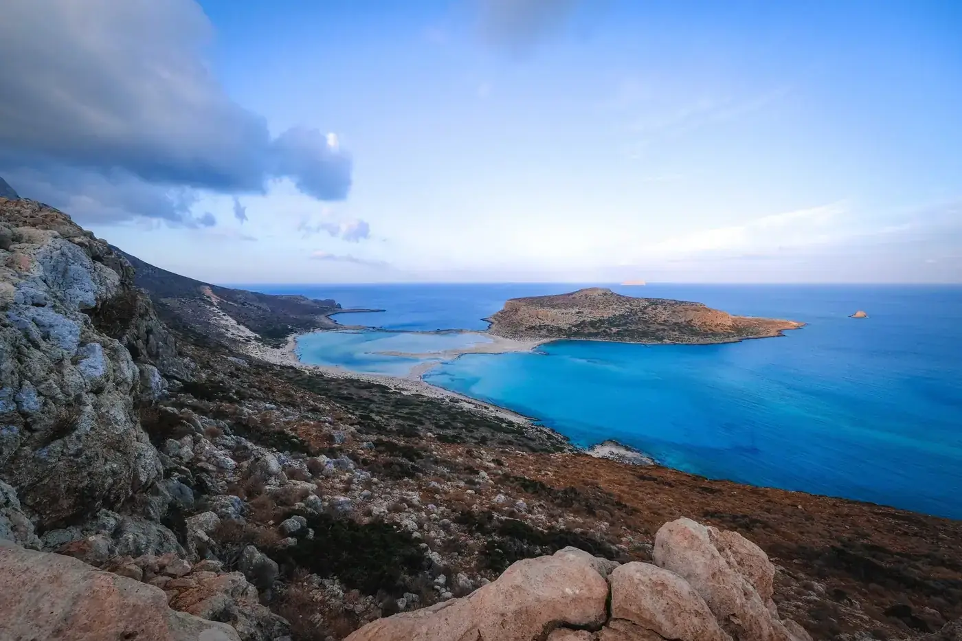 Panoramic view of a serene coastal landscape with turquoise waters and rocky shores.