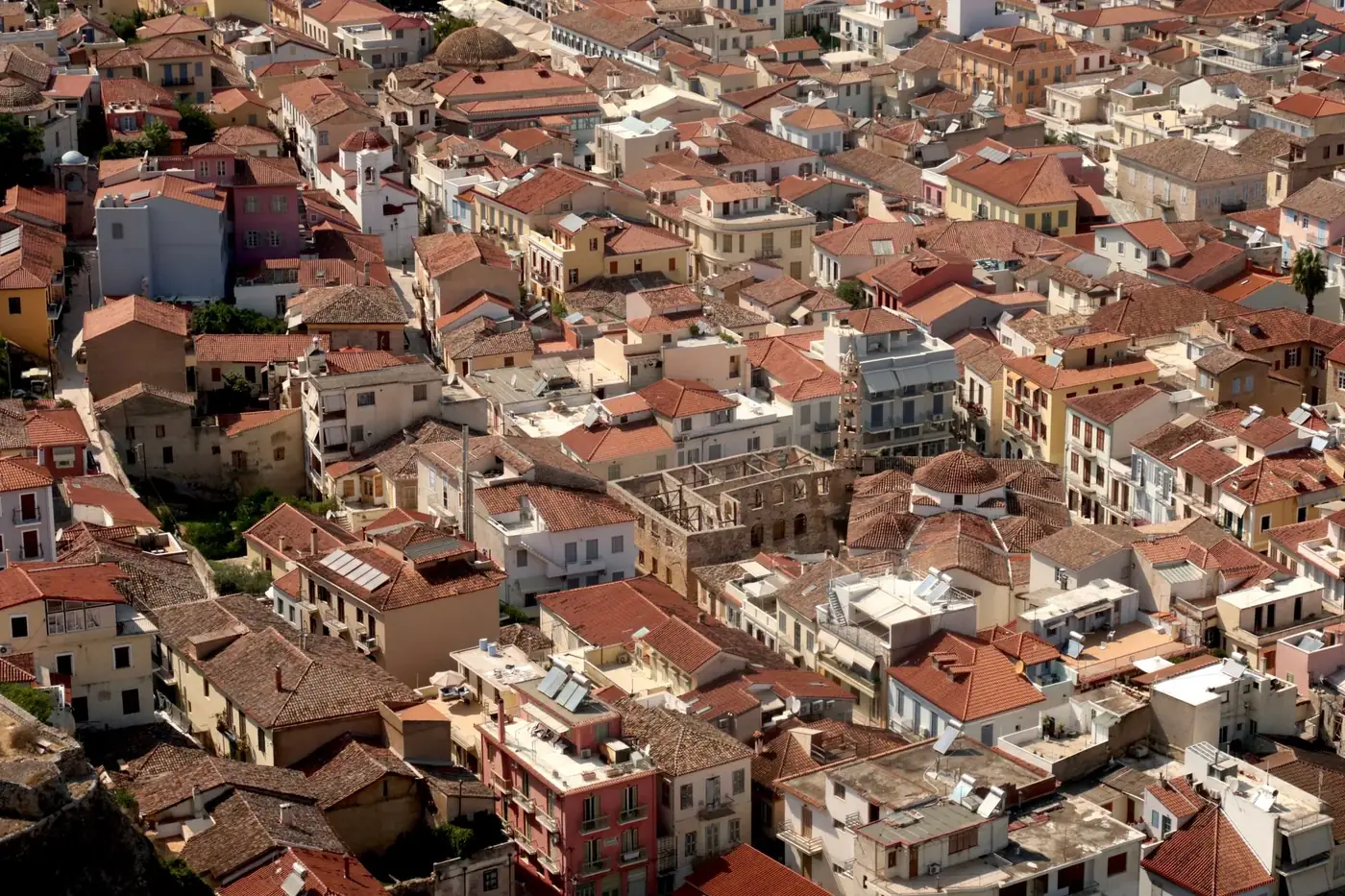 Explore the charming red rooftops of Nafplion, Greece, with its clustered Mediterranean architecture.