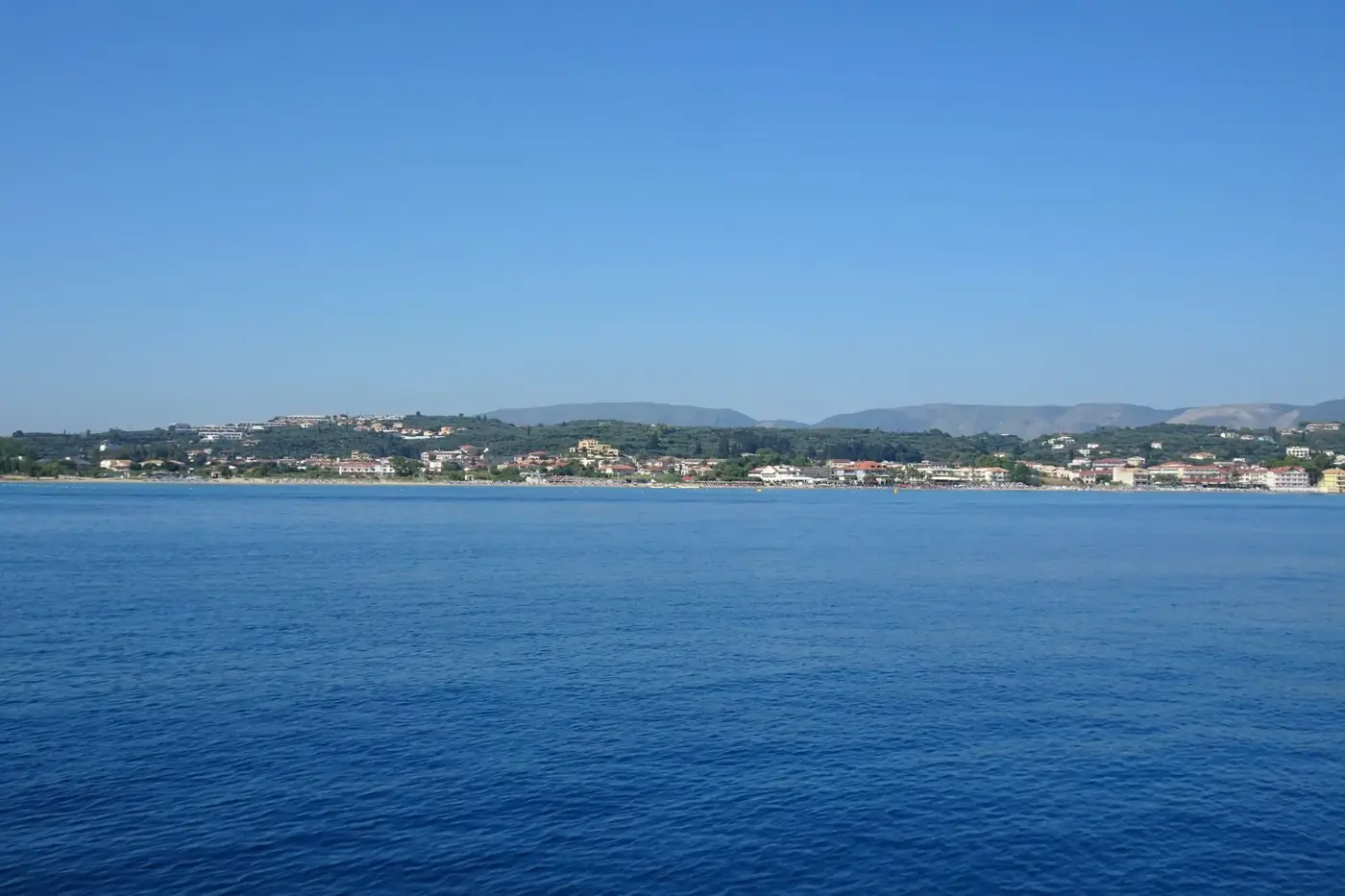 Peaceful view of Zakynthos Island coastline with calm sea and clear sky.