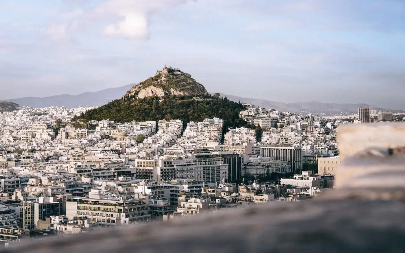 Explore the stunning cityscape of Athens with Mount Lycabettus at its center, captured beautifully in this aerial shot.