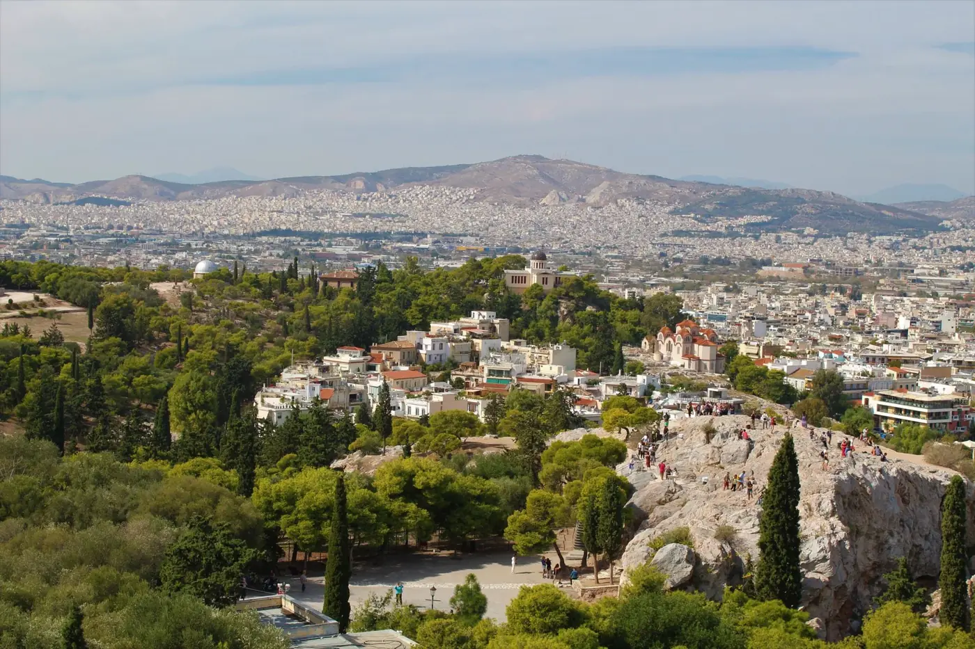 Breathtaking view of Athens, Greece with lush greenery and urban landscape from a hilltop.