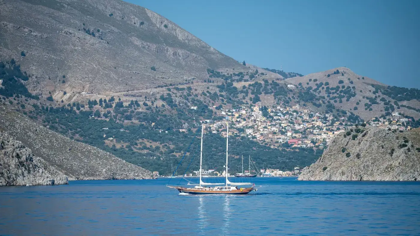 A stunning aerial view of Syros Island's cityscape and the Aegean Sea under a clear blue sky.