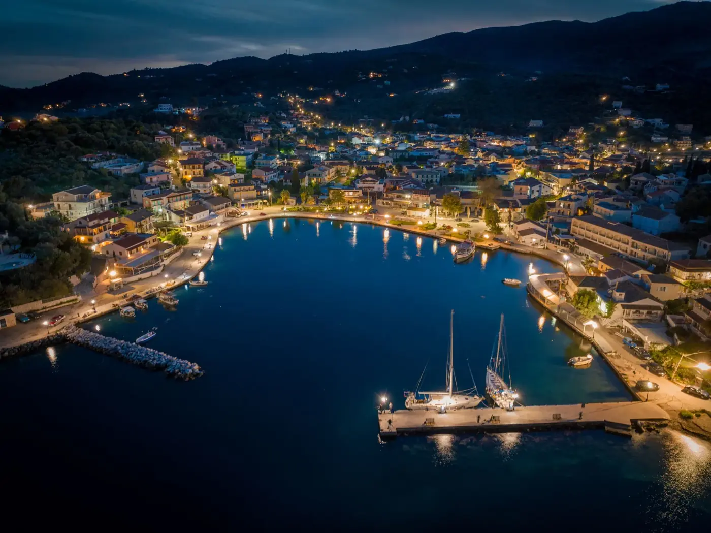 Stunning aerial night view of illuminated harbor and town in Κέρκυρα, Greece.
