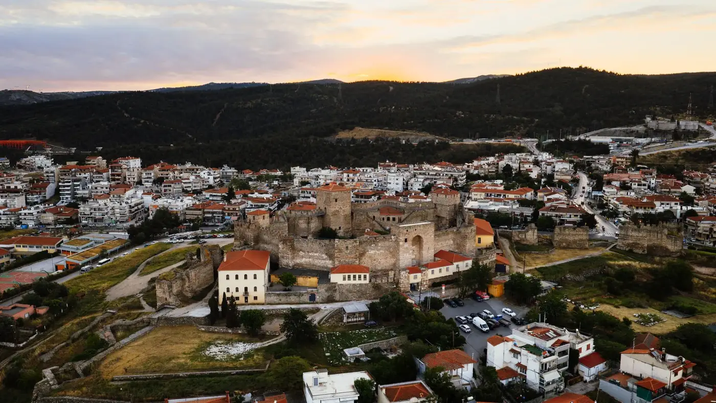 Aerial view of Heptapyrgion fortress and cityscape in Thessaloniki, Greece at sunset.