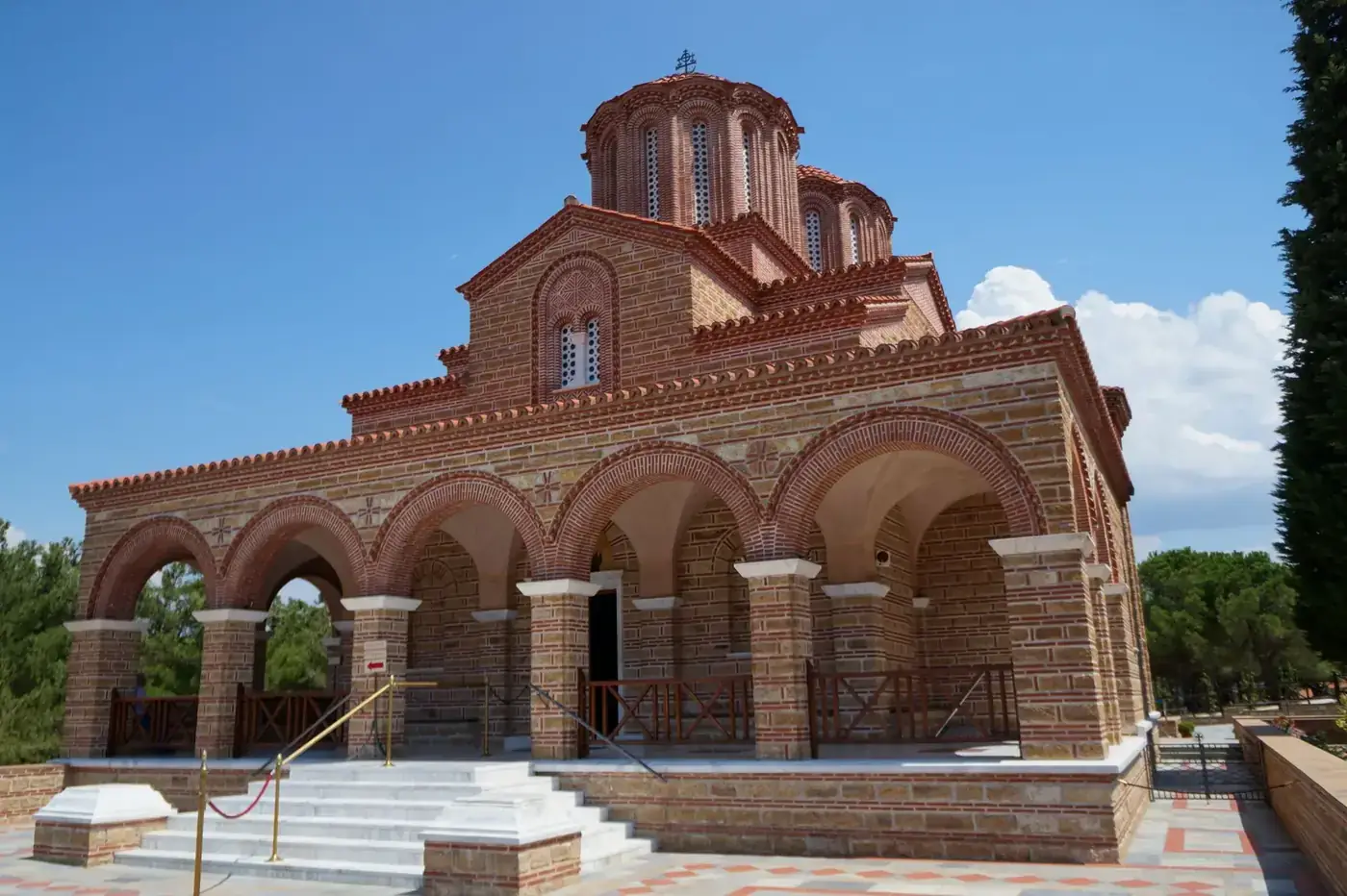 Traditional Greek monastery in Souroti, featuring stunning architecture under a blue sky.