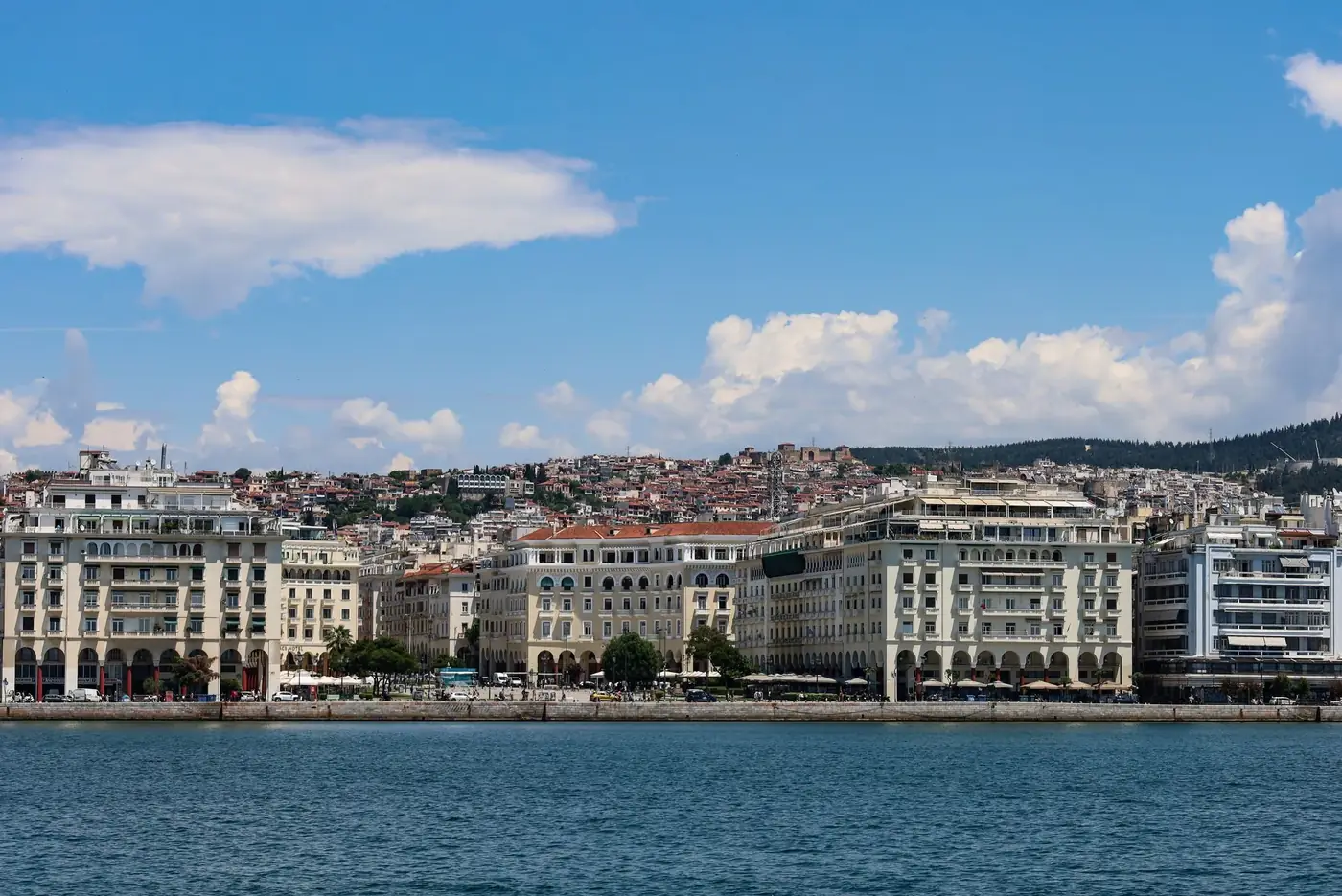 Scenic view of Thessaloniki's iconic waterfront buildings against a bright summer sky.