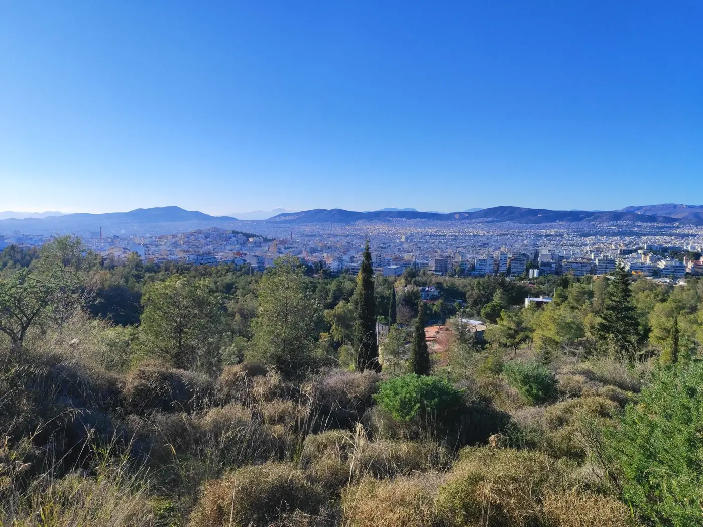 Panoramic landscape of Athens city skyline with surrounding hills.