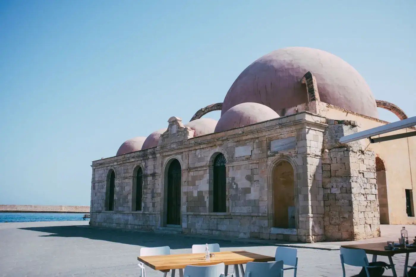 View of a historic Ottoman mosque with domed architecture by the sea.