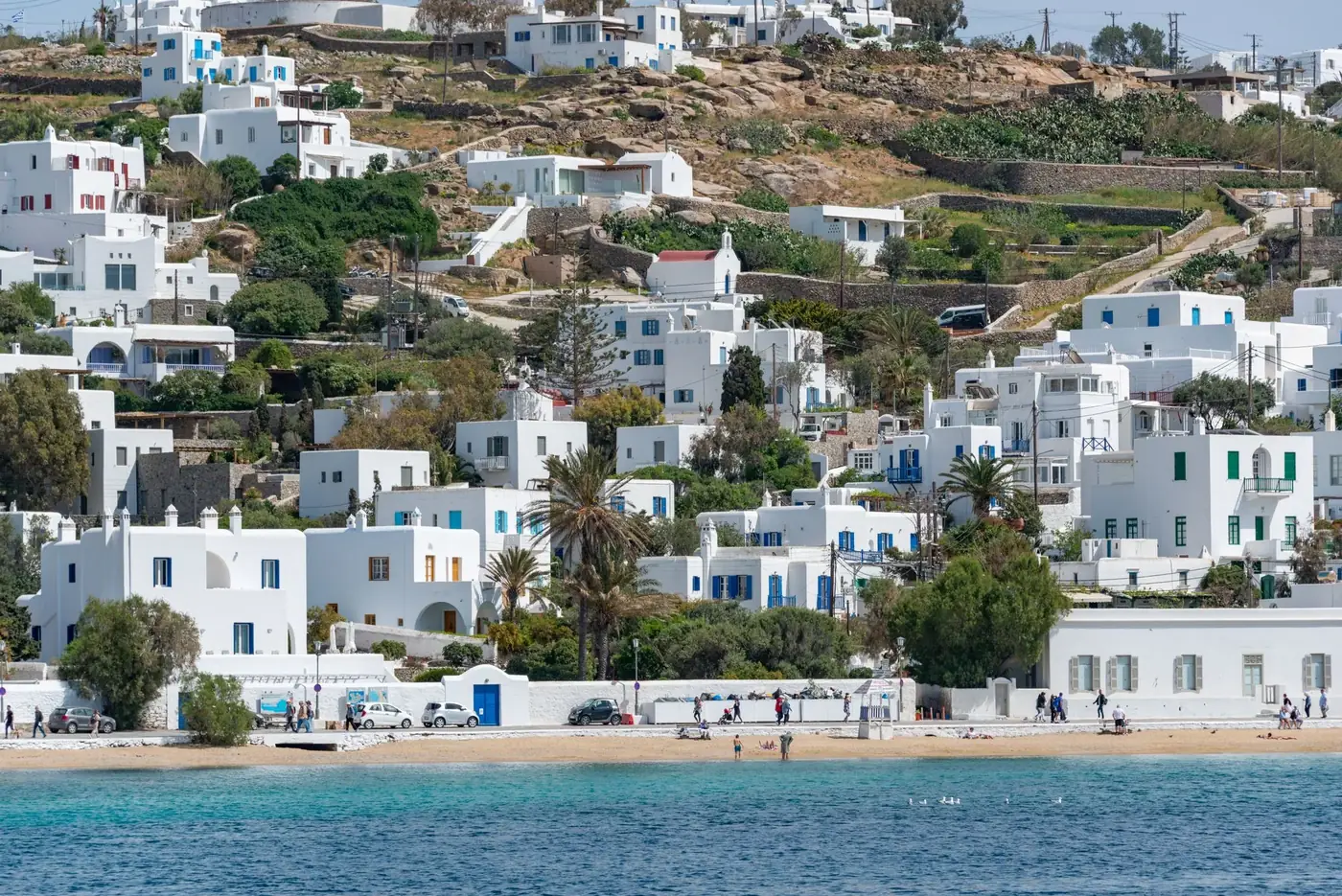 Beautiful Mykonos waterfront with iconic white houses and crystal-clear sea under bright summer skies.