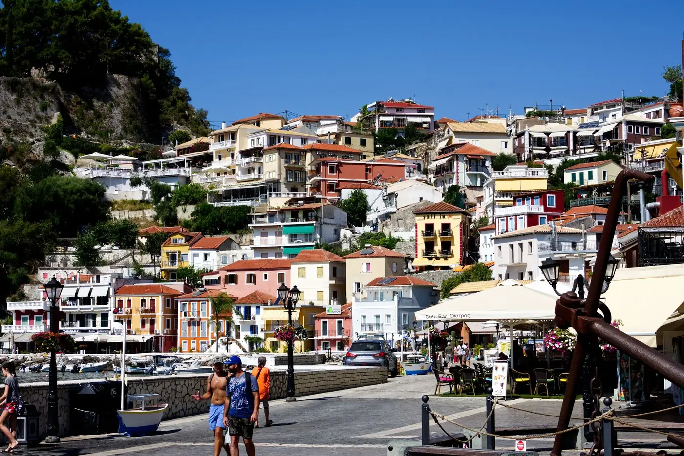 Vibrant hillside houses in Parga, Greece, under a clear blue sky. A picturesque coastal scene.