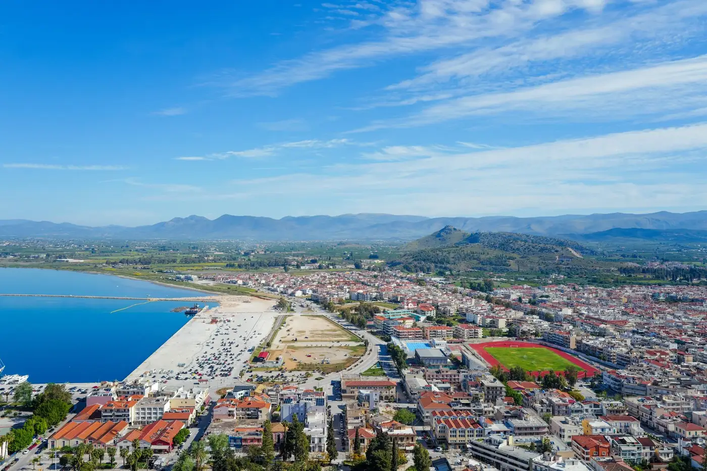 Stunning aerial view of a coastal city with vibrant blue waters and clear skies.