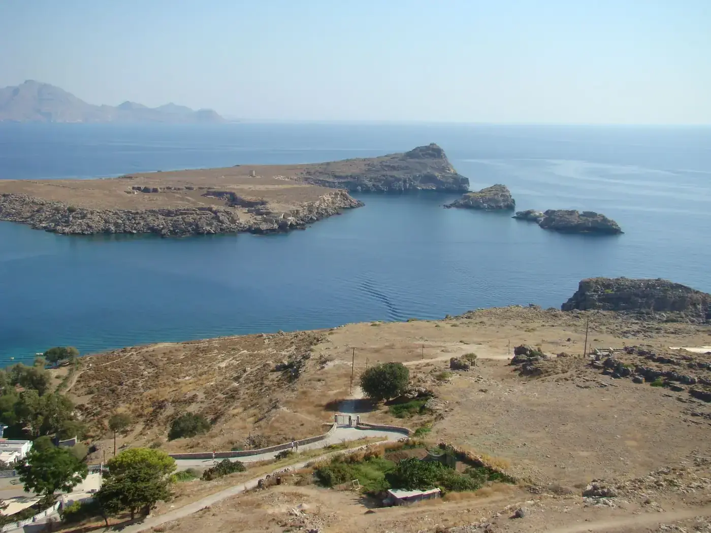 Aerial view of St. Paul's Bay in Rhodes, showcasing the rocky coastline and clear blue sea.