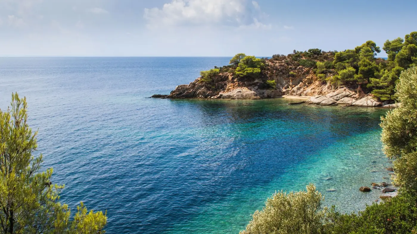 Stunning view of a rocky coastline with clear turquoise waters in Greece.