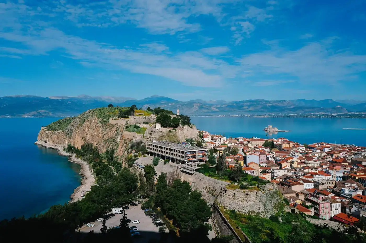 Aerial view of Nafplio, Greece, showcasing a historic fortress and vibrant seascape.