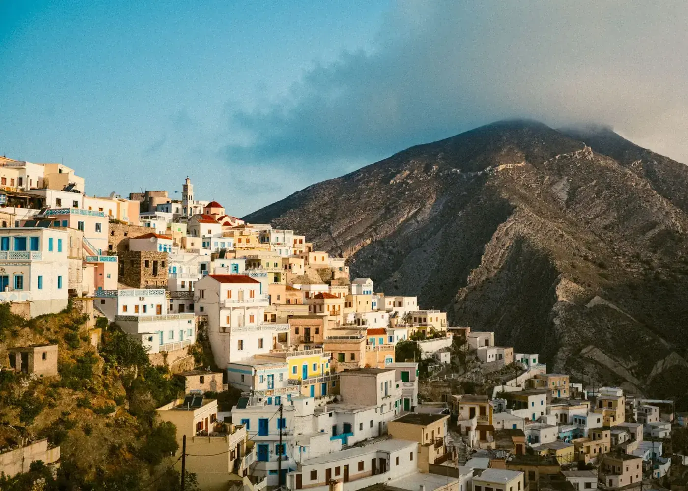 Scenic view of Olympos, Greece with colorful houses and a mountain backdrop.