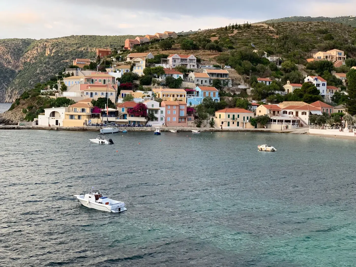 Picturesque Mediterranean village with colorful buildings and boats on a serene coast.