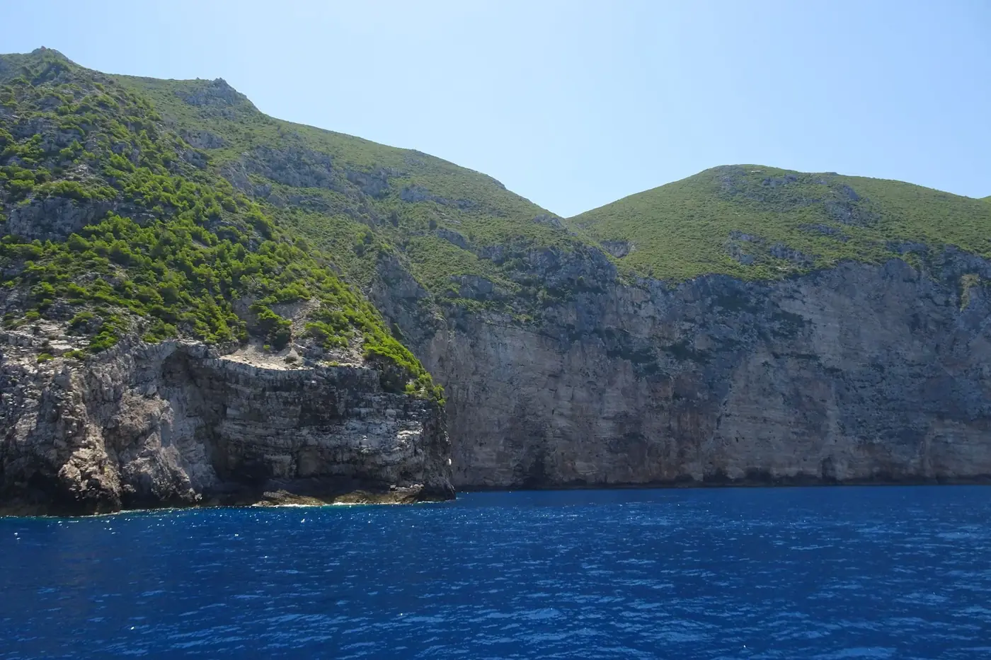 Stunning view of rugged cliffs and azure sea under clear blue skies in summer.