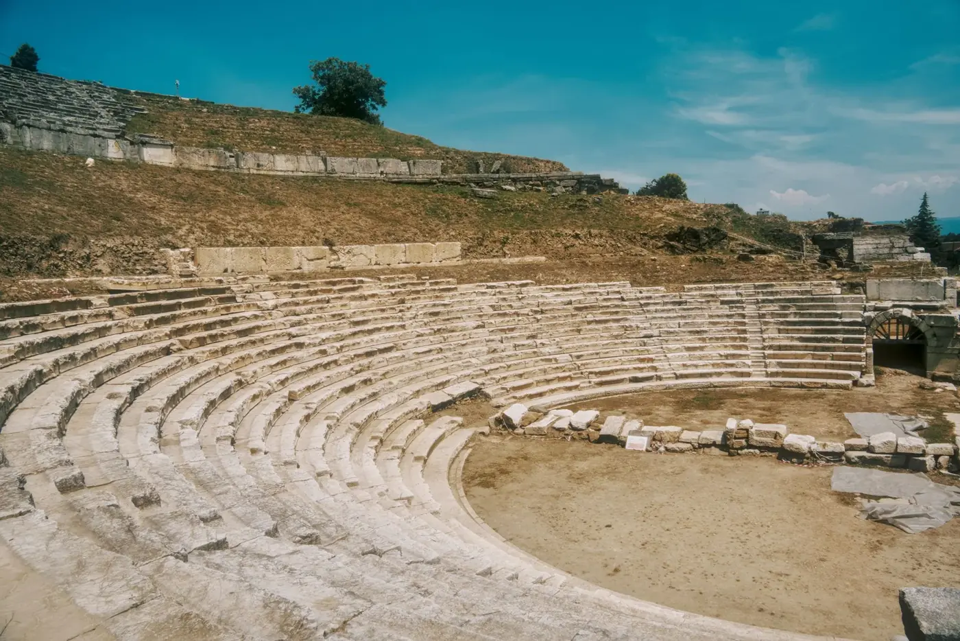 Explore the stunning ancient amphitheater ruins under a clear blue sky in Düzce, Türkiye.