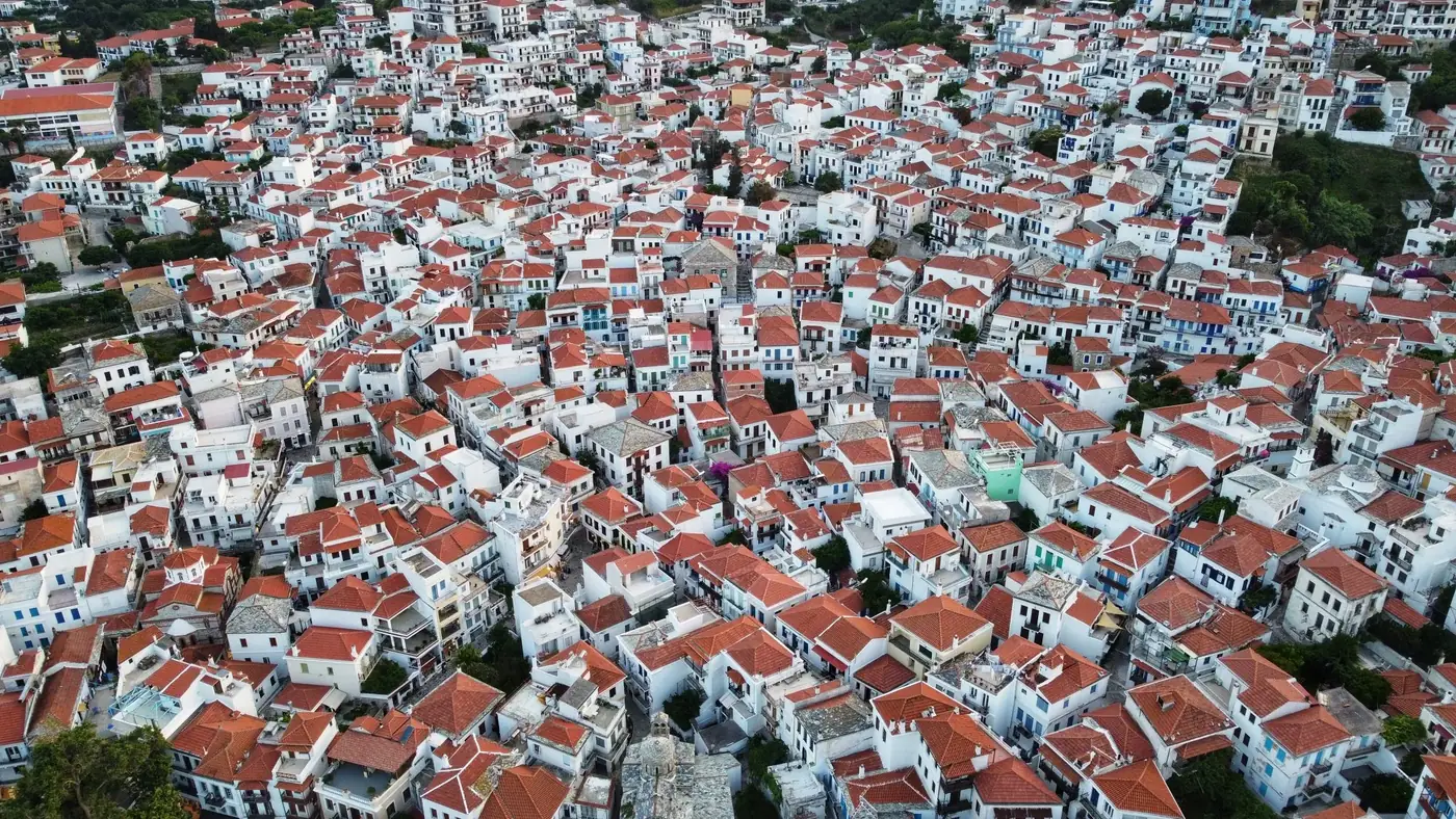 Picturesque aerial view of Skopelos town with traditional red-tiled roofs in Greece.