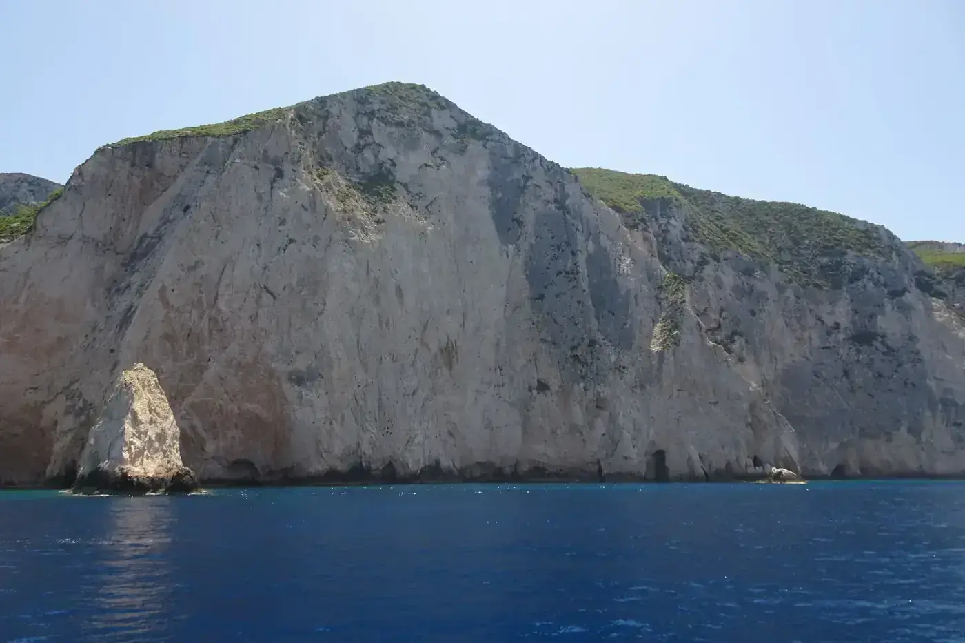 Stunning view of a sheer cliff by the sea in Zakynthos, Greece, under a clear summer sky.