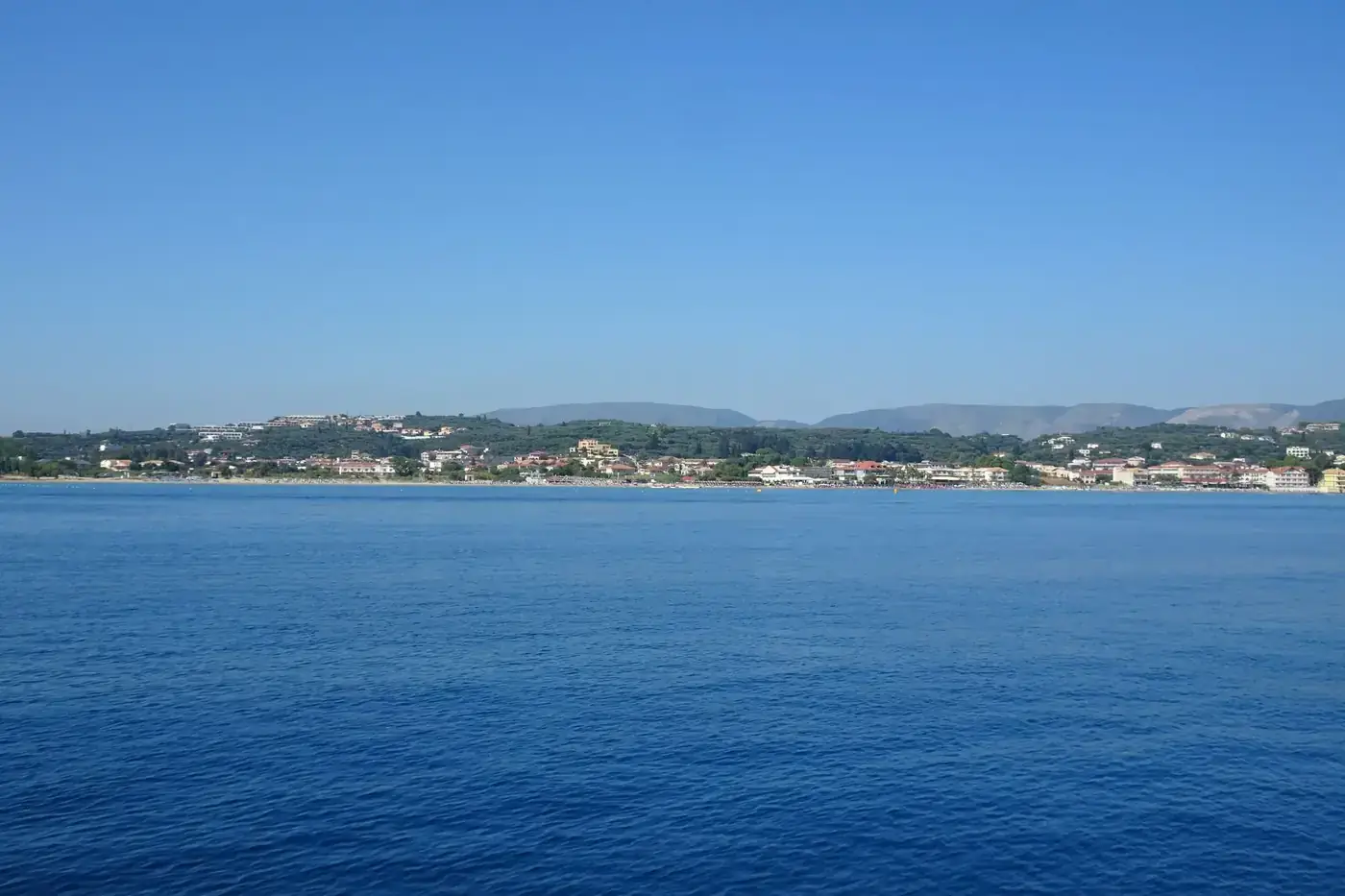 Peaceful view of Zakynthos Island coastline with calm sea and clear sky.