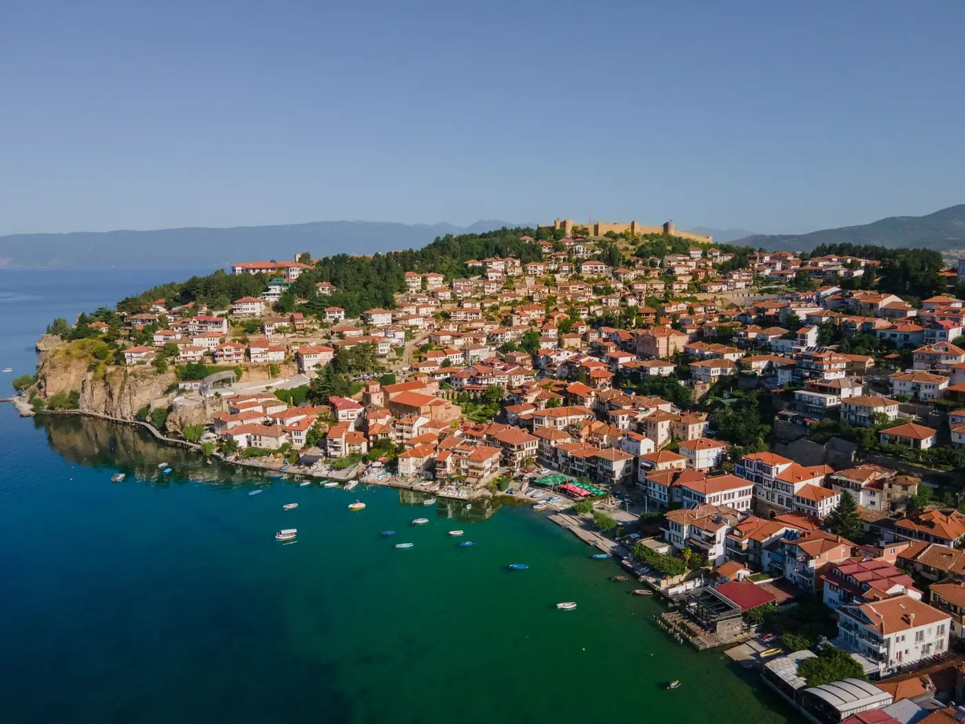 Stunning aerial shot of Ohrid's historic waterfront with clear waters and traditional architecture.
