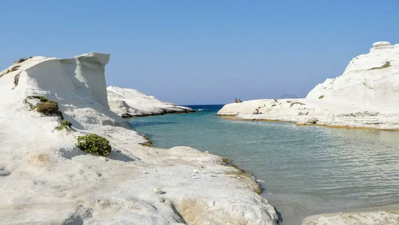 Stunning Sarakiniko Beach with white rock formations and azure waters under a clear blue sky.