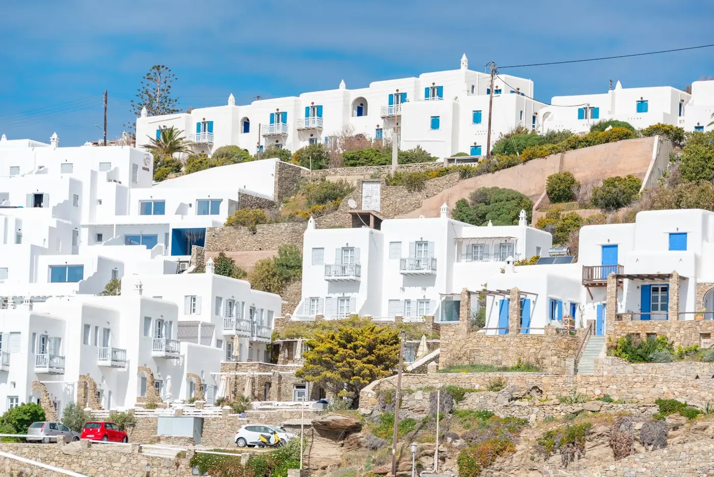 Whitewashed buildings with blue accents reflect classic Cycladic style on a Greek island.