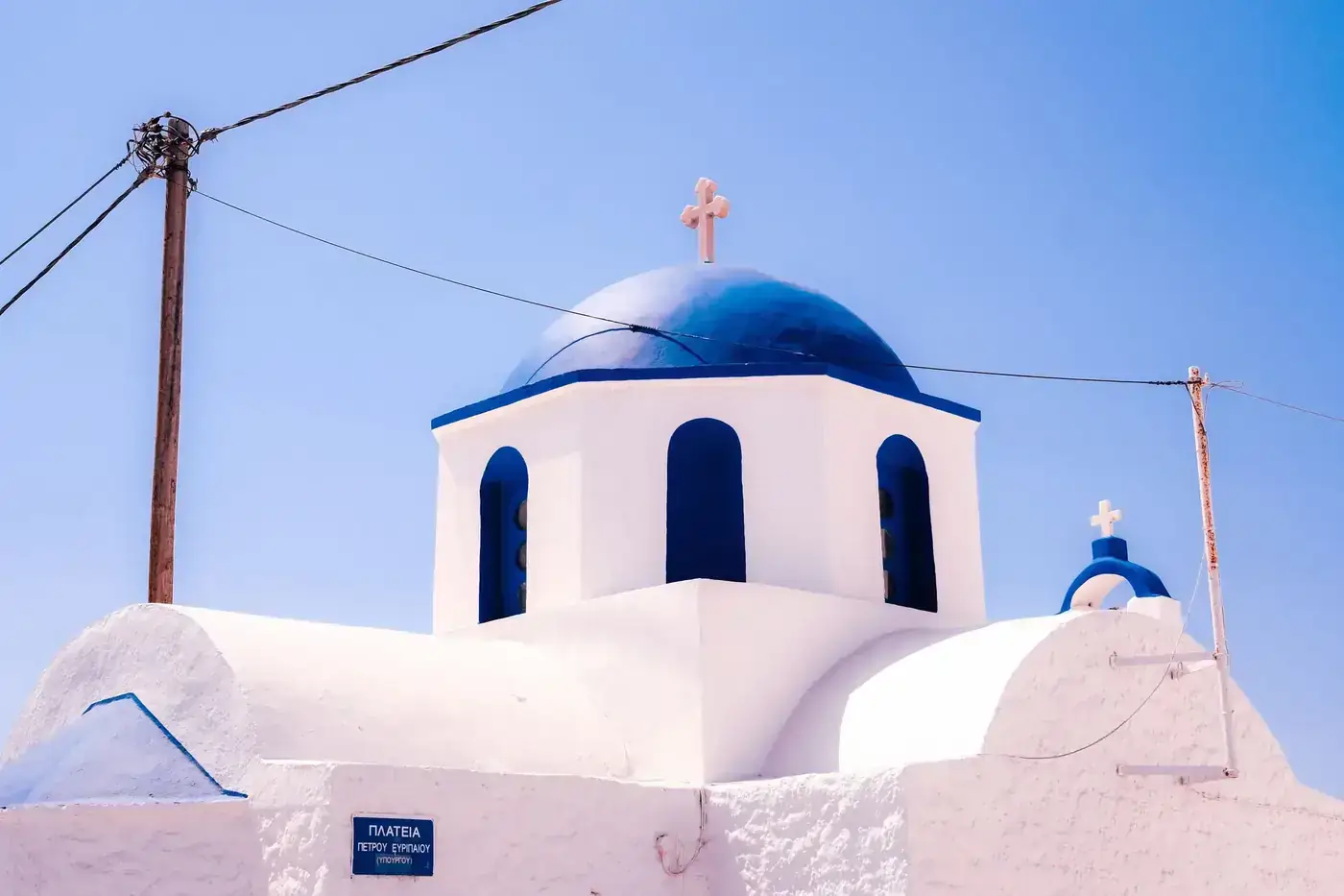 Peaceful view of the Aegean Sea with distant Greek islands under a clear sky.