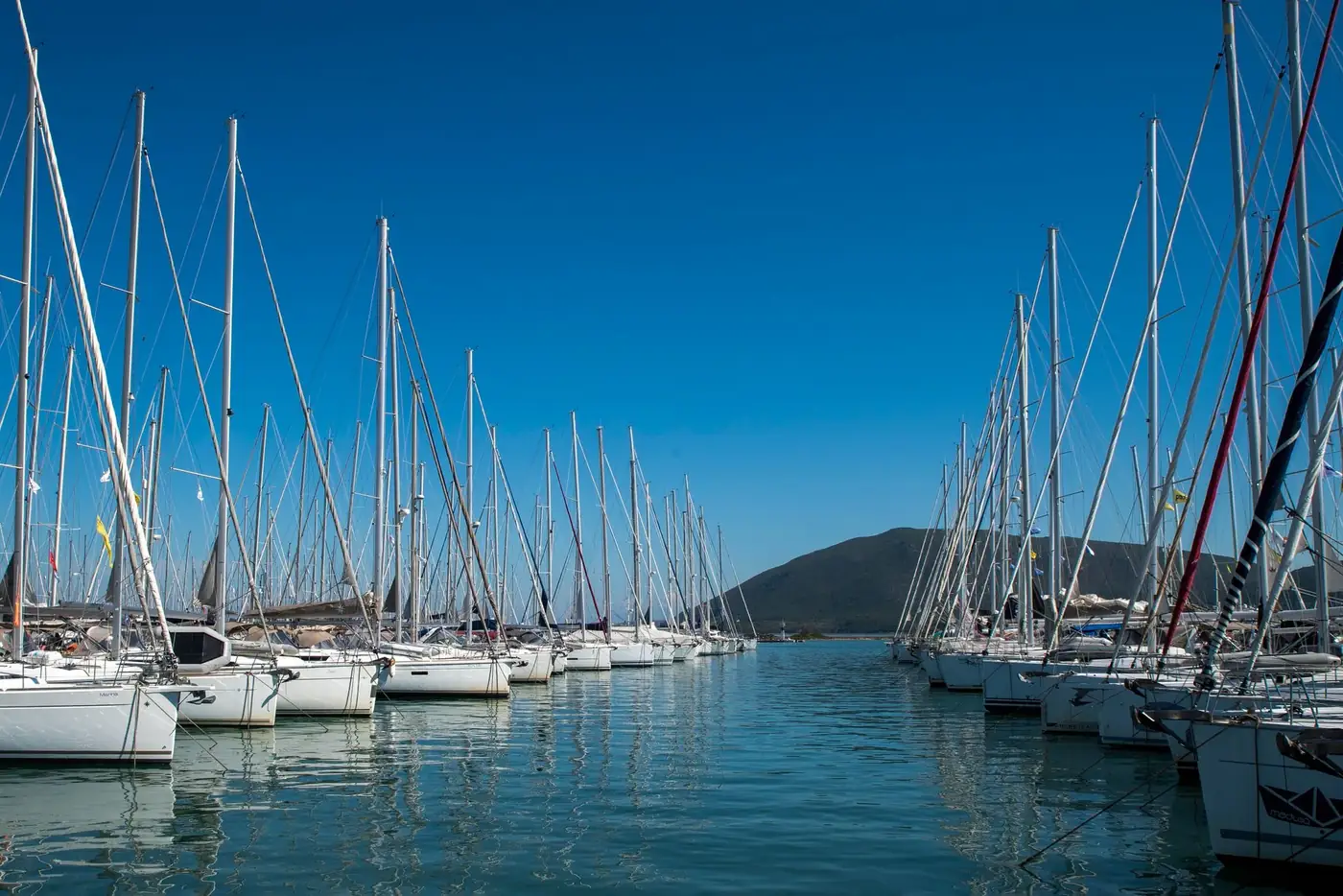 A stunning view of luxury yachts moored at Lefkada Marina under a clear blue sky.
