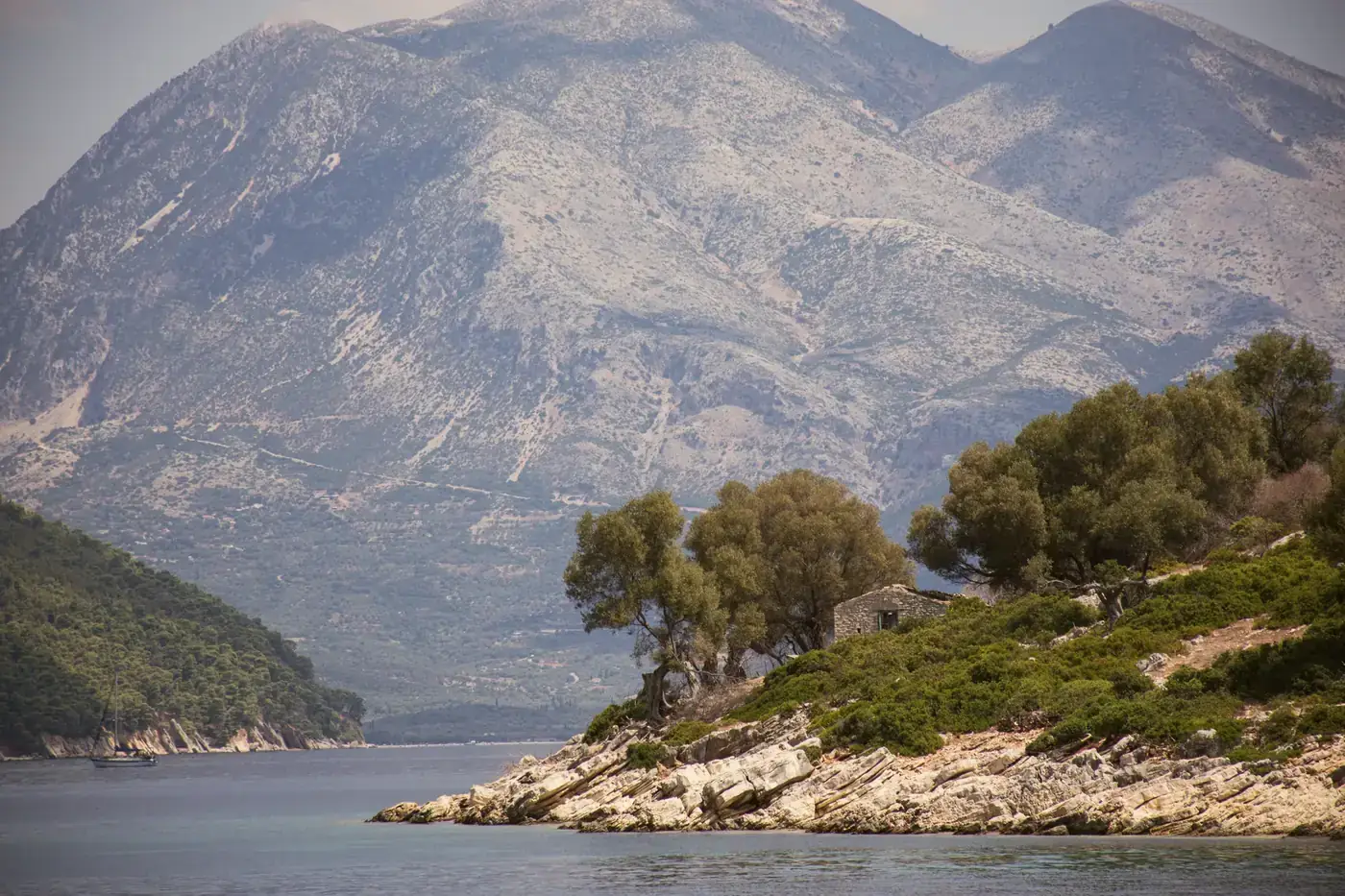 Peaceful mountain landscape with trees and clear water at Kastos, Greece.