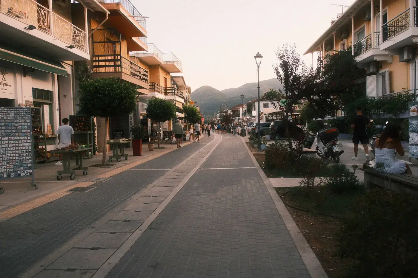 Quaint village street at twilight with cafes and outdoor dining, exuding a warm and relaxed atmosphere.