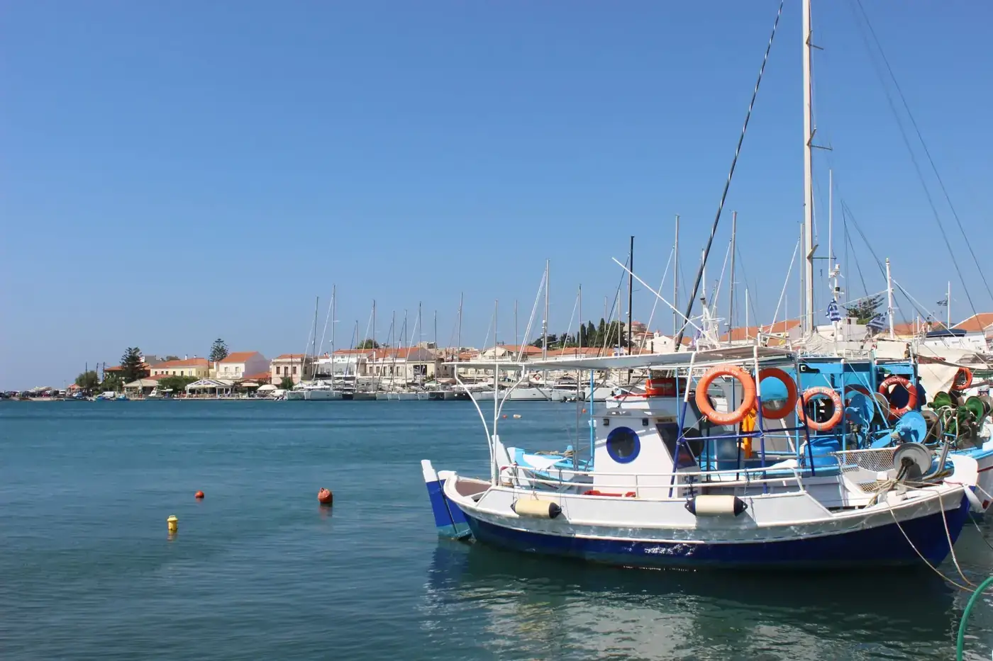 A picturesque view of fishing boats docked at Samos harbor under clear blue skies.