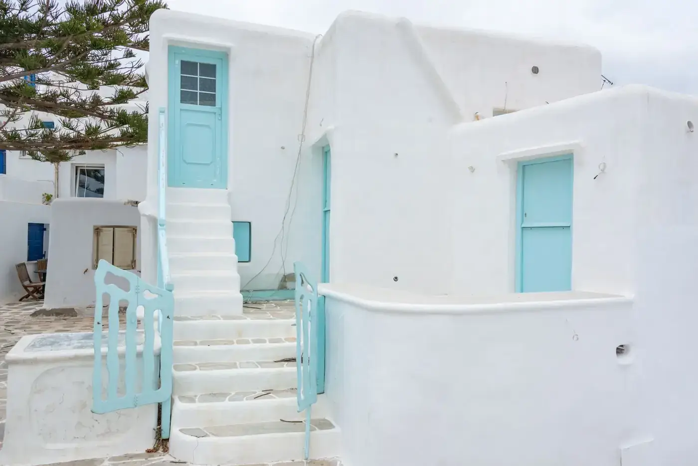 Whitewashed building with pastel blue accents, a traditional Greek architectural style.