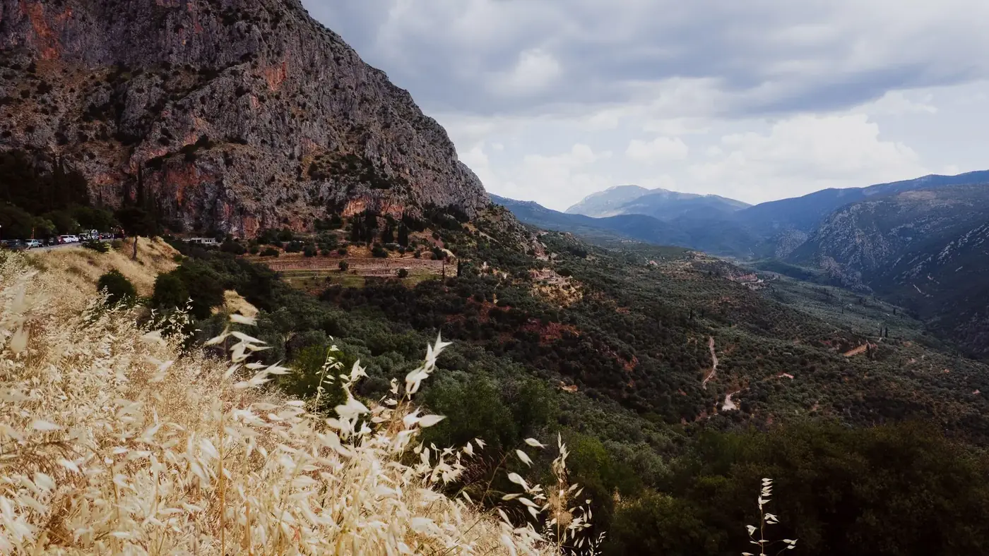 Breathtaking landscape of Delphi's rugged mountains and valleys under a dramatic sky.