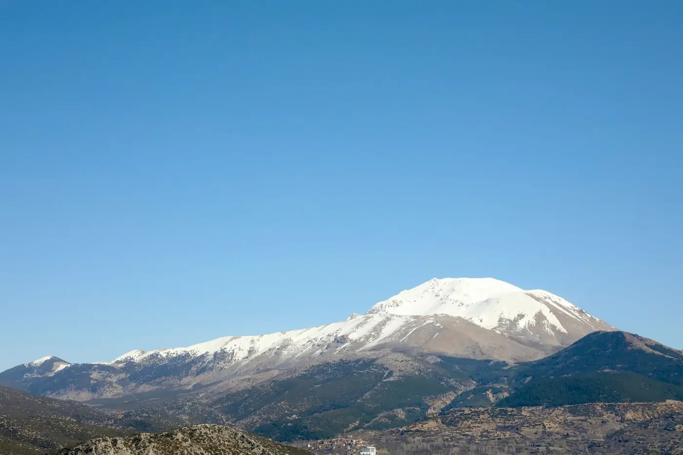 Breathtaking snow-capped mountain landscape under a clear blue sky in Isparta, Türkiye.