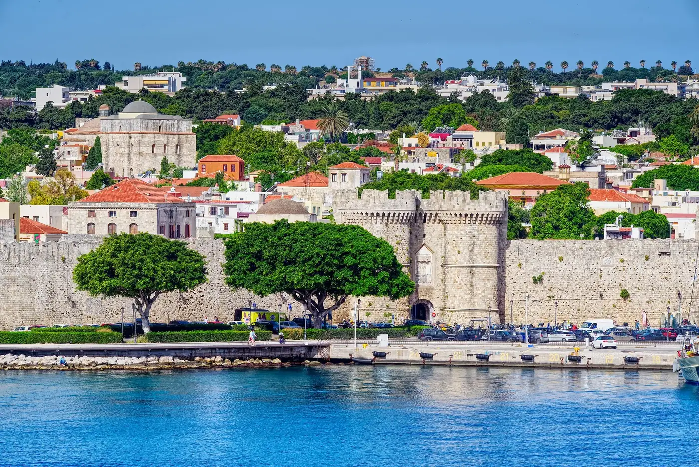 Beautiful view of the historic fortress in Rhodes, Greece, with vibrant cityscape and waterfront.