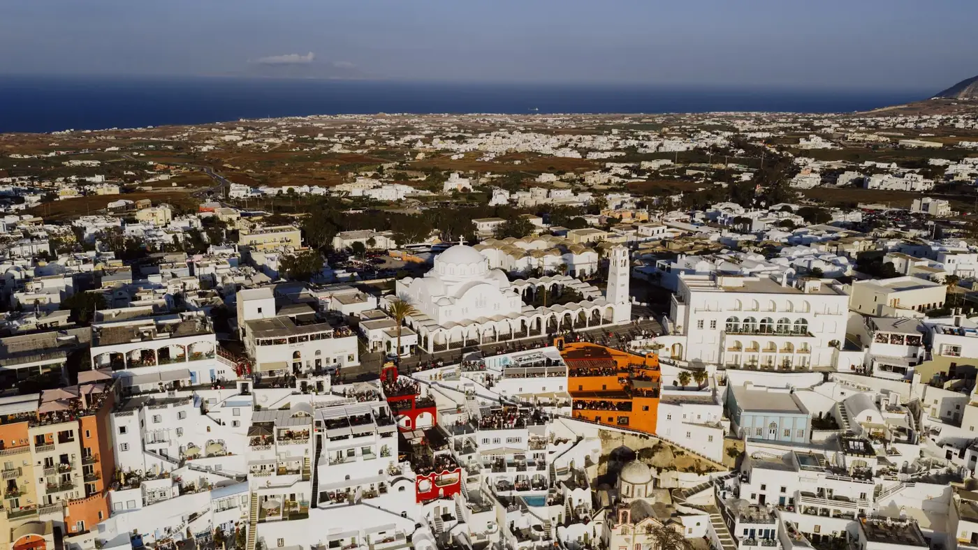 A stunning aerial shot of Fira, showcasing iconic white buildings against the blue sea.