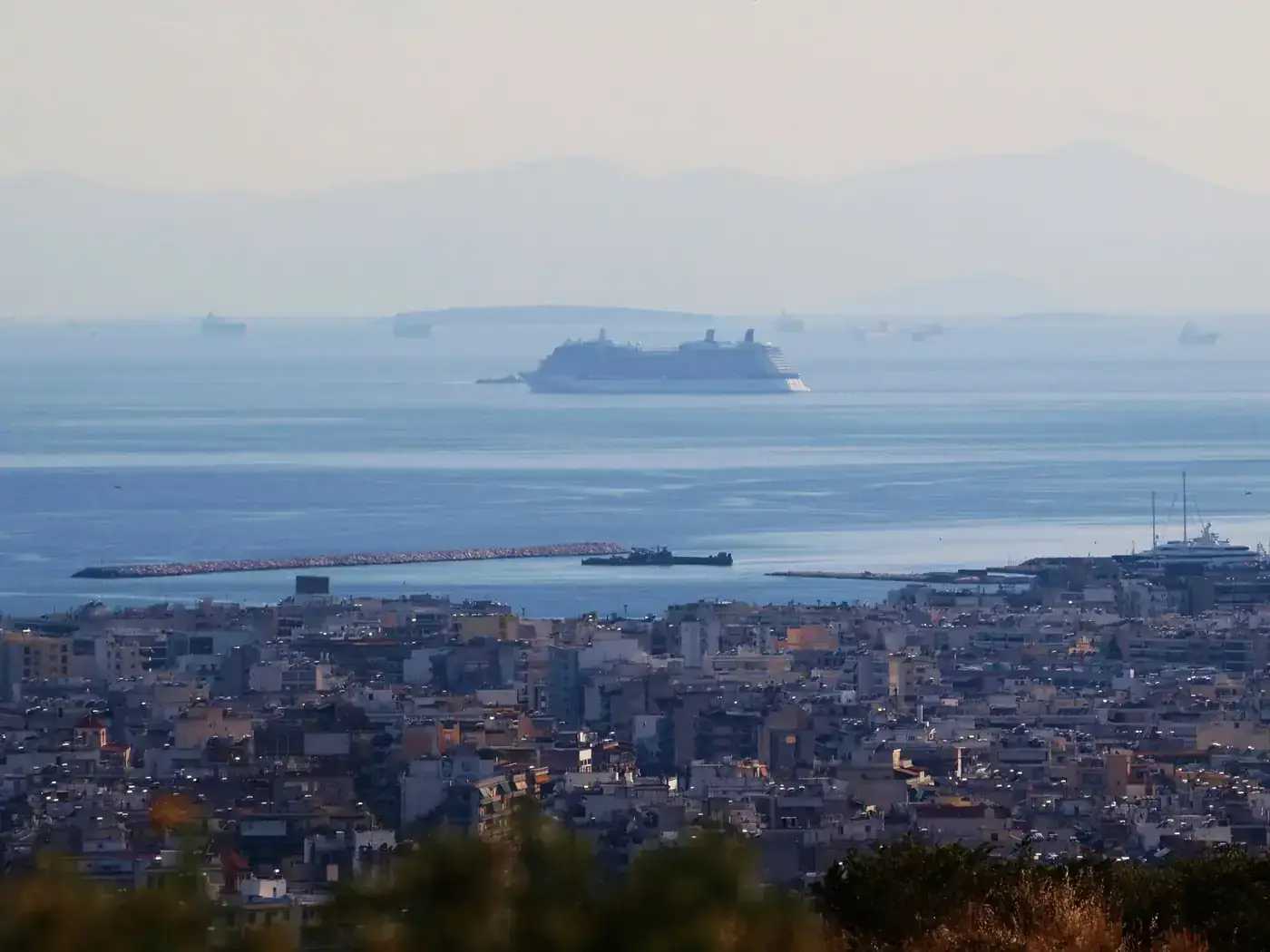 Panoramic view of Athens coastline with cruise ships in the Mediterranean Sea, highlighting urban and maritime scenery.