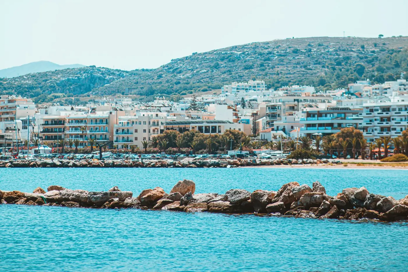 Beautiful coastal cityscape of Rethymnon, Greece, featuring serene blue waters and rocky shoreline.