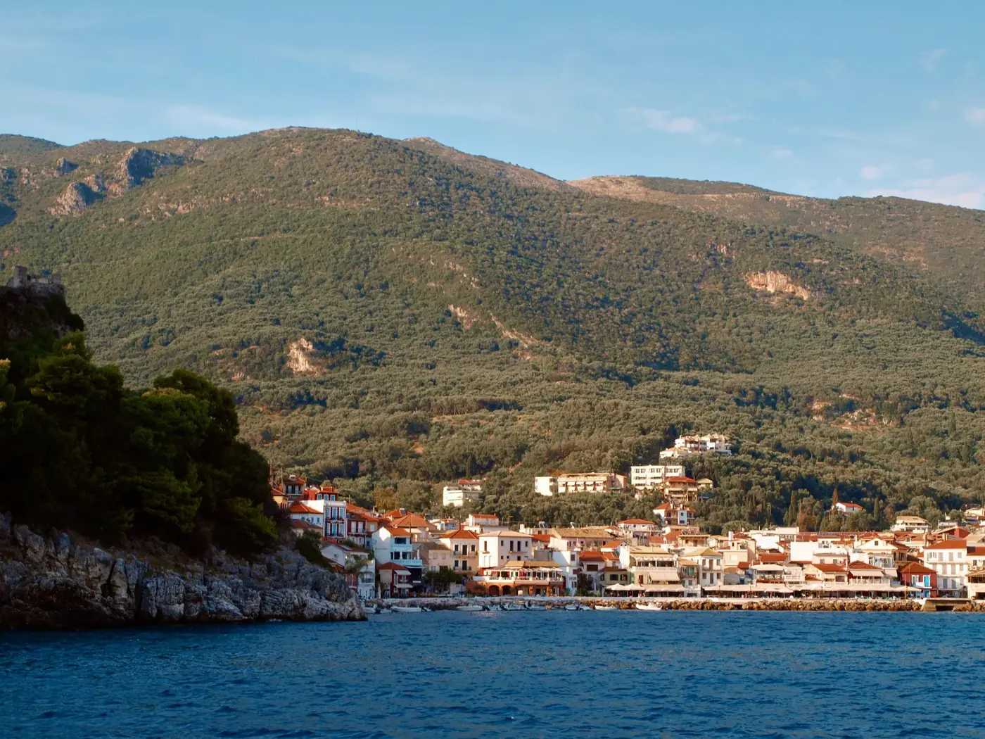 Explore the charming coastline of Parga, Greece, nestled between the Ionian Sea and lush green hills.