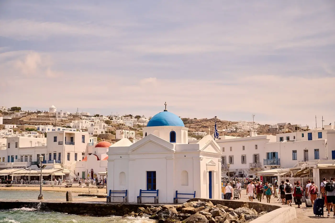 Explore the picturesque Agios Nikolaos Church by the sea on a sunny day in Mykonos, Greece.