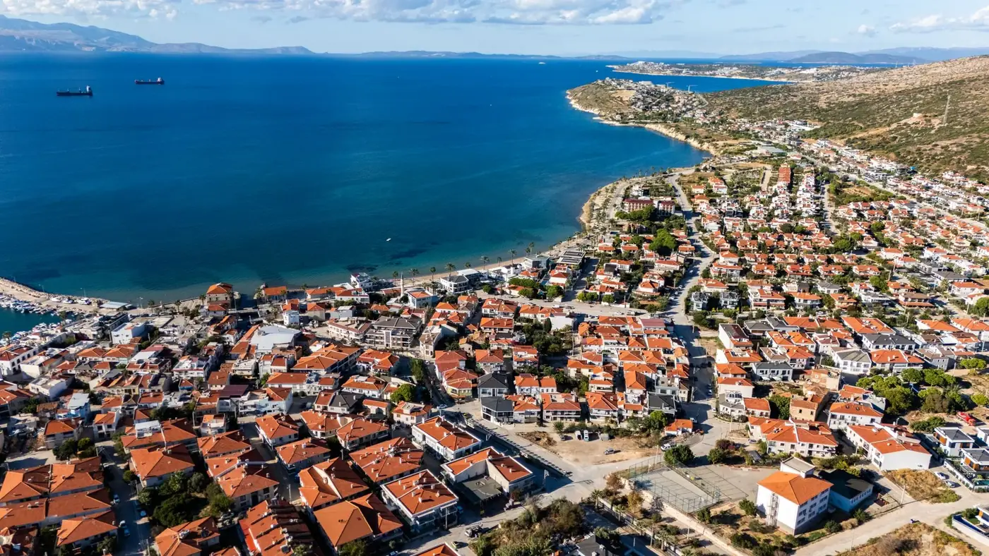Stunning aerial view of a quaint coastal town with red rooftops along the Aegean Sea.